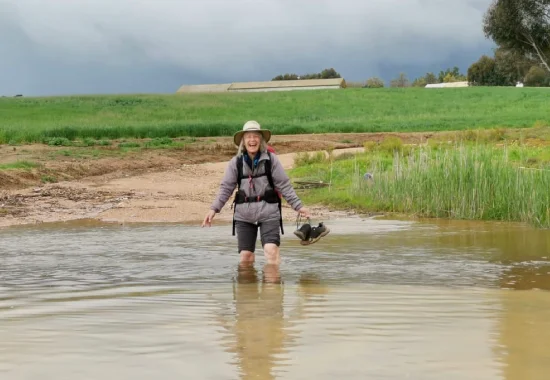 About Us - walking through river