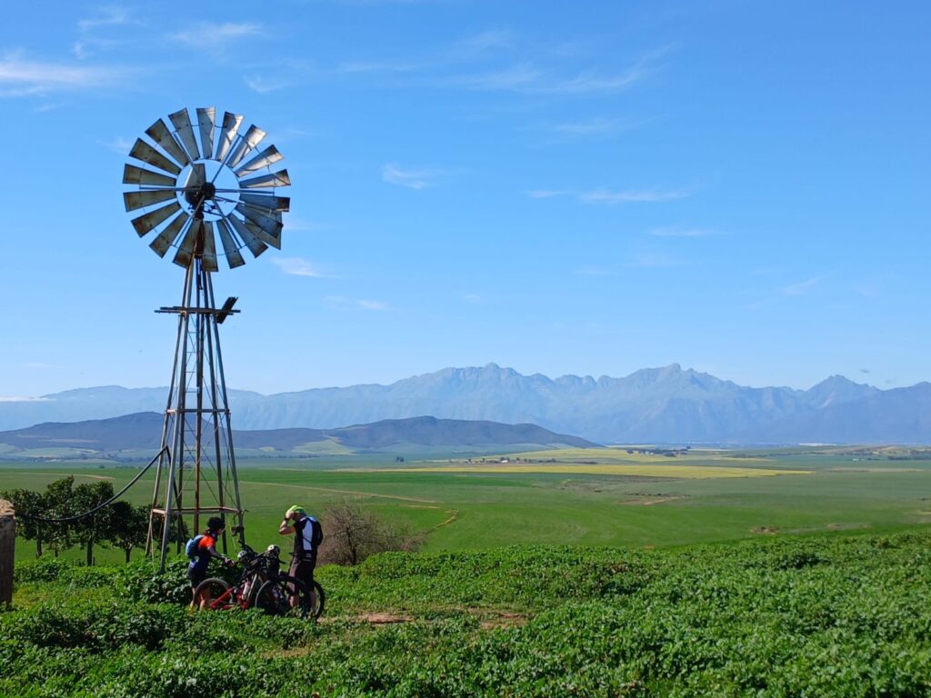 Pilgrims sitting under a windmill in the farmlands