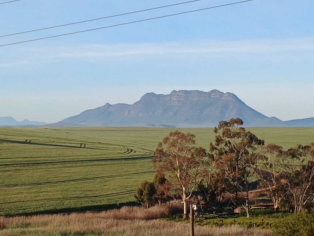 A landscape of mountains and fields and trees